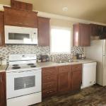 Kitchen with white appliances in the Classic 1202 at Recreational Resort Cottages and Cabins in Rockwall, Texas 