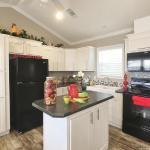 Black appliances and white cabinets in the Classic series 1205 on display at Recreational Resort Cottages and Cabins in Rockwall, Texas. 