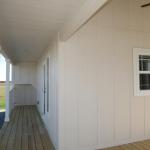 Side porch on the Platinum Model P-528SL presented by Recreational Resort Cottages and Cabins located in Rockwall, Texas. cabinsupercenter.com