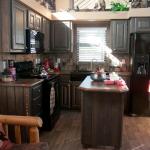 Kitchen and Movable Island in the Platinum model P-528FPSP (Meadowview) presented by Recreational Resort Cottages and Cabins located in Rockwall, Texas. CabinSuperCenter.com